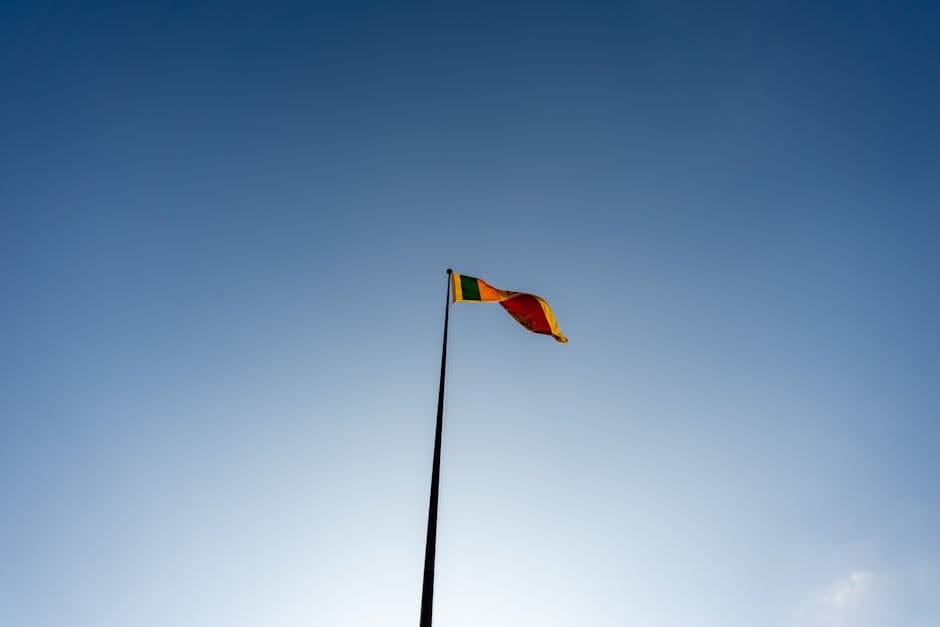 A majestic view of the Sri Lankan flag waving against a clear blue sky in Colombo.