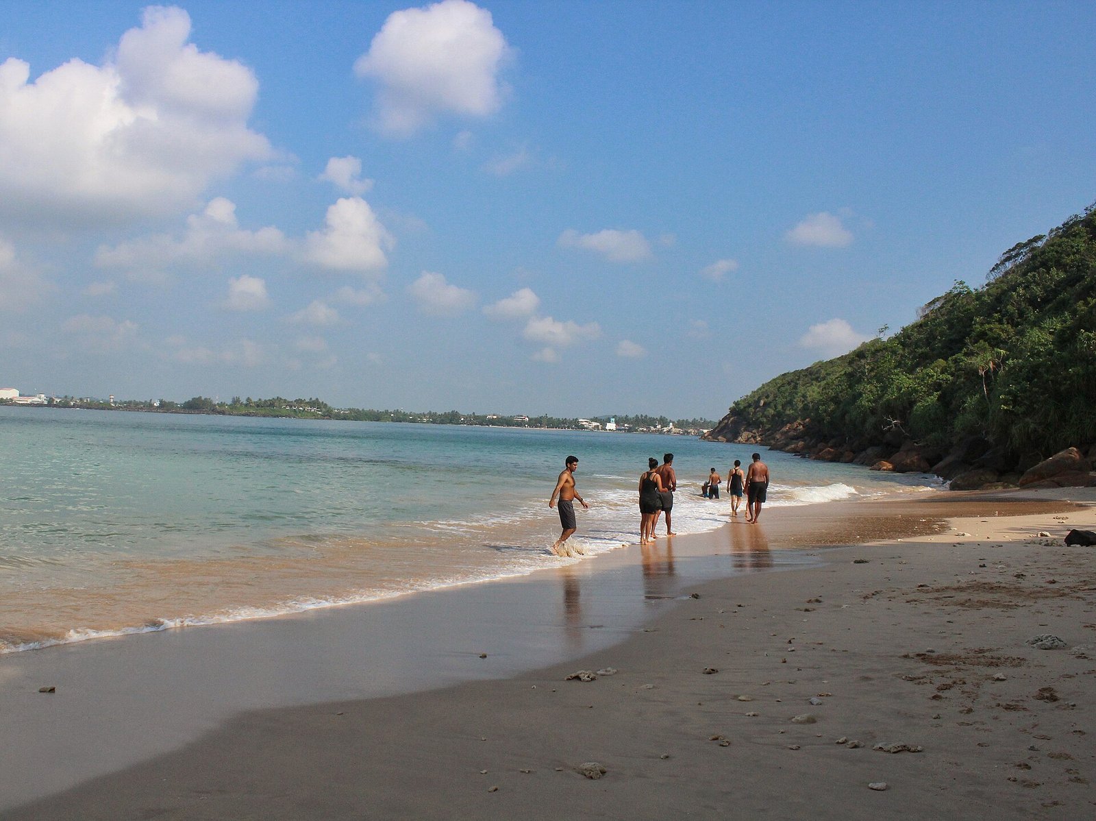 Swimmers on the sheltered sand of Jungle Beach near Galle