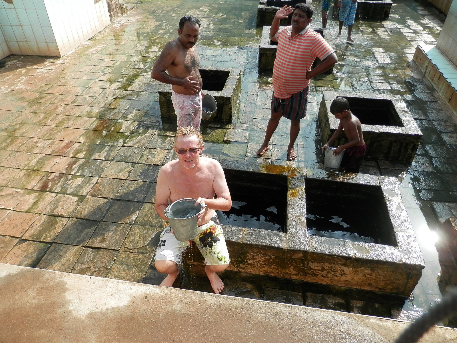 Visitors bathing with buckets at the Kanniya hot spring wells