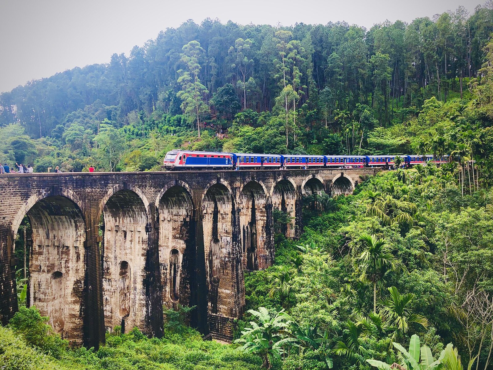 Blue train crossing the Nine Arch Bridge near Ella