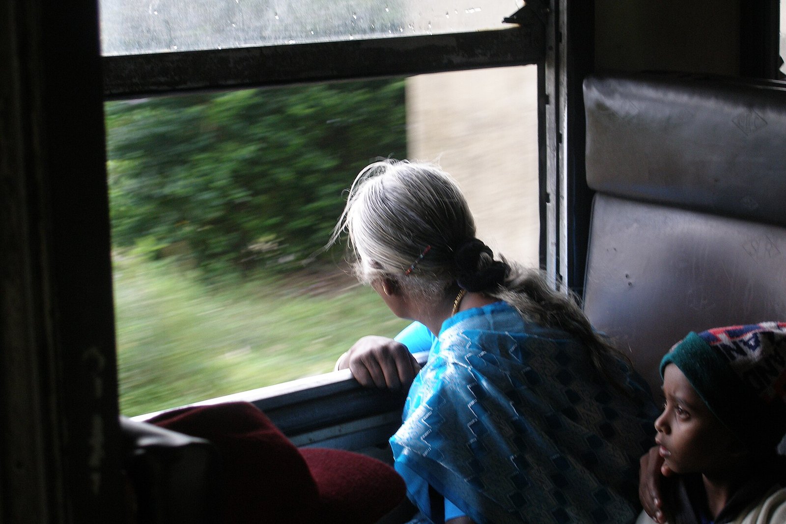 Passengers looking out of a train window in the hills near Haputale
